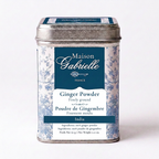 A metal tin of Maison Gabrielle Ginger powder from India featuring a blue and white floral pattern with a dark blue label, set against a plain white background.