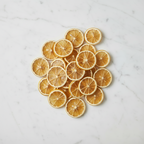 Stack of dried lemon slices on a marble surface