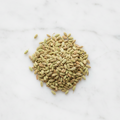 Top-Down Perspective of Maison Gabrielle Premium Whole Fennel Seeds on a Bright White Marble Counter, Showcasing the Natural Greenish-Gold Hue and Ribbed Texture of the Artisanal Spice